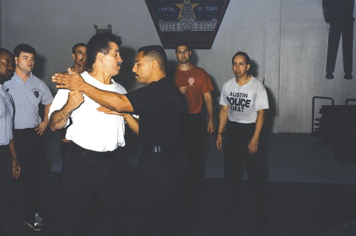 Police Combative Academy principles Louis Marquez, left, and Hans Marrero, right, demonstrate an open-hand technique designed to knock a knife out of a suspect’s hand.