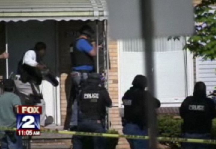 Detroit officers breach the door of a nearby apartment to search the premises. Image via FOX News.