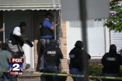 Detroit officers breach the door of a nearby apartment to search the premises. Image via FOX News.