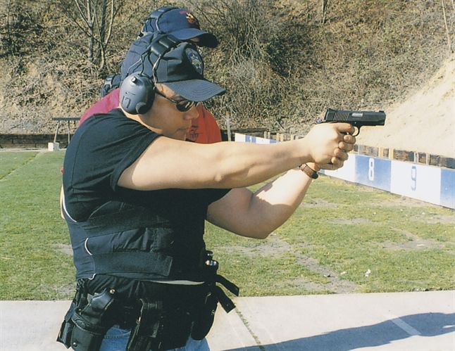 As instructor Dennis Quilio watches, Steve O’Keefe squeezes off a shot from his new duty pistol, a Kimber Pro Carry II Model 1911.