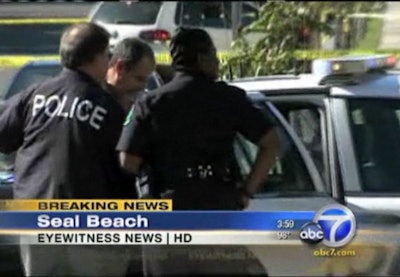 Seal Beach (Calif.) Police officers load the mass-shooting suspect into a squad car. Screenshot: ABC News.
