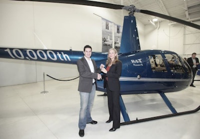 A Robinson Helicopter associate presents the keys for the 10,000th copter to a rep from dealer Audi Helicopters. Photo: Robinson Helicopter.
