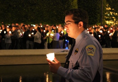 A Bismarck (N.D.) Police officer honors the fallen at the 2011 Police Week candlelight vigil. Photo: Paul Clinton