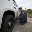 A tester attaches an optical sensor to a Chevy Tahoe to measure top speed and acceleration. Photo: MSP