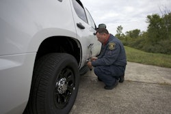 A tester attaches an optical sensor to a Chevy Tahoe to measure top speed and acceleration. Photo: MSP