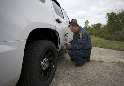 A tester attaches an optical sensor to a Chevy Tahoe to measure top speed and acceleration. Photo: MSP