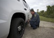A tester attaches an optical sensor to a Chevy Tahoe to measure top speed and acceleration. Photo: MSP