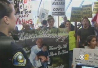 Protestors gathered in the Anaheim Police Department's lobby in July. Screenshot via CBS 2.
