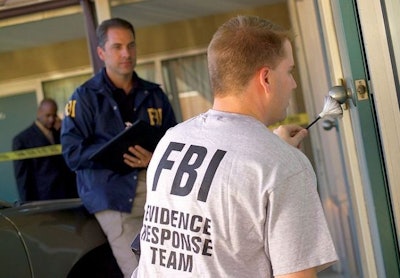A member of the FBI's Evidence Response Team collects fingerprint evidence. Photo via FBI/Wikimedia.