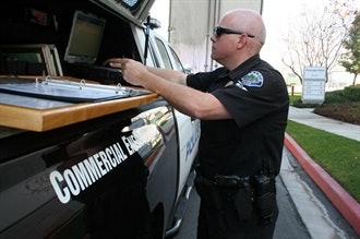 Officer Craig Durling checks the license status of a commercial driver. Photo courtesy of TPD.