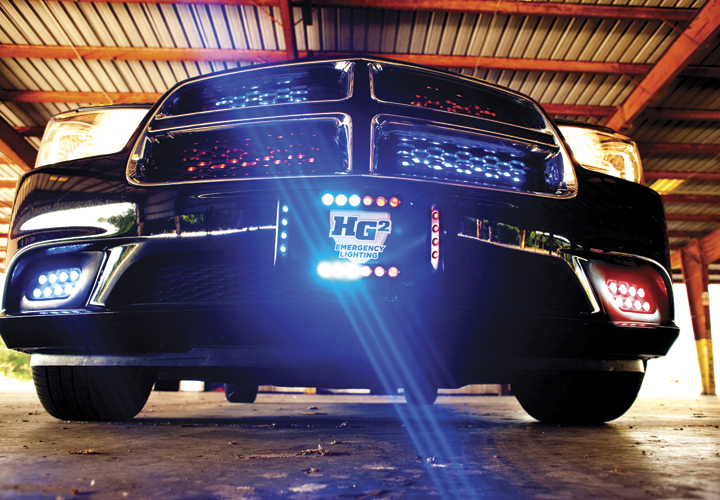 Adamson Industries' HG2 Crossfire is an outward-facing tag bezel with an emergency lighting system designed for maximum visibility. The Crossfire lighting design features optics mounted at grazing angles to enhance visibility by emitting light onto a broader field of view. There are multiple color combinations and flash patterns available. Constructed of aluminum with a black powder coat finish for durability, it utilizes factory mounting locations for ease of installation and its design can fit to all vehicles.