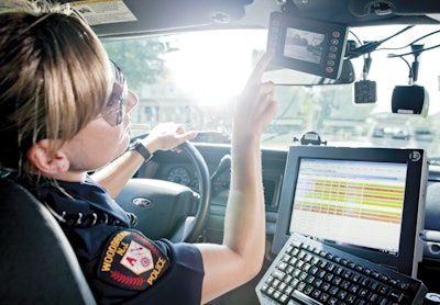 Officer using L-3 in-vehicle systems, including FlashBack 3 video, a VOne mobile computer, and PatrolScout integrated video streaming and GPS locator. Photo courtesy of L-3.