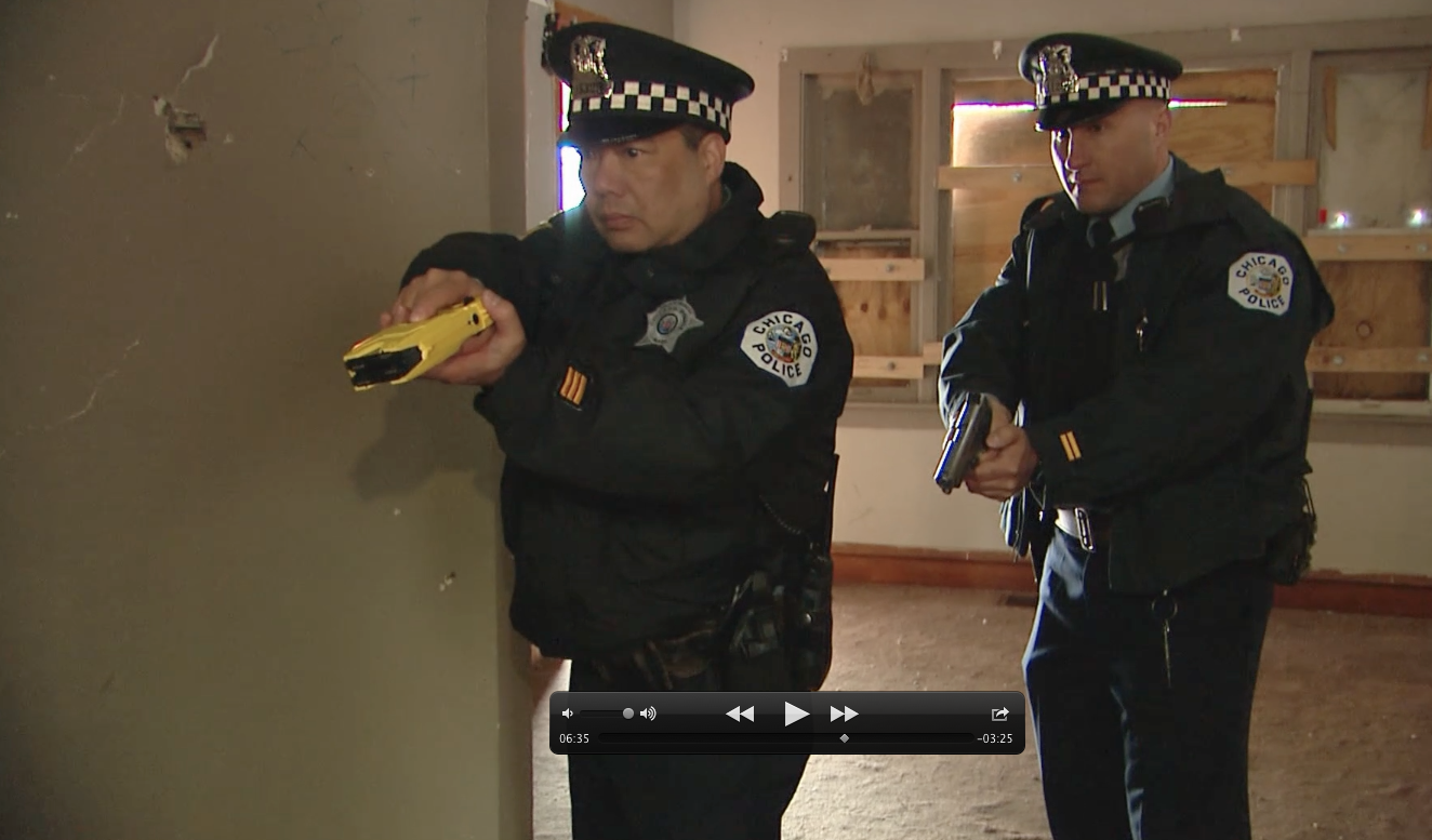 Chicago officer demonstrate how to use a TASER on a dog. Note the cant of the device, so that the prongs spread horizontally on the animal's body. (Photo: National Canine Research Council)