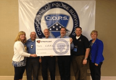 Streamlight employees present a check to representatives of Concerns of Police Survivors. (Photo: Streamlight)