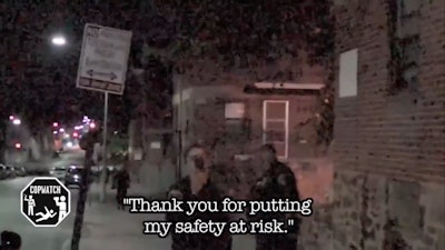 Baltimore officer uses cellphone to video 'cop-watcher' videoing officers. (Photo: Screen shot from Baltimore Sun video)
