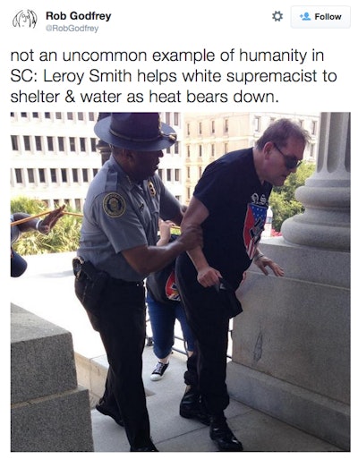 Leroy Smith, director of the South Carolina Department of Public Safety, comes to the aid of a heat-stricken man wearing a swastika T-shirt at a weekend Klan rally in Columbia. (Photo: Rob Godfrey via Twitter)