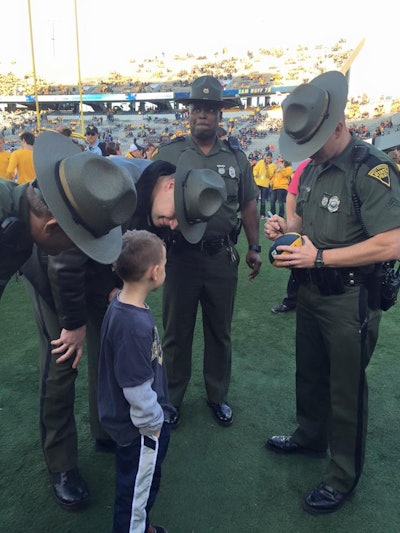 A little boy at a University of West Virginia football game surprised a group of state troopers by asking for their autographs. (Photo: Facebook)