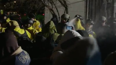 Minneapolis officers use pepper spray on protesters outside of police station. (Photo: Minneapolis Star-Tribune video screenshot)