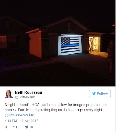 Twitter post from Action News Jax report Beth Rousseau shows projected Blue Lives Matter flag on homeowner's property.