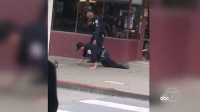 A San Francisco officer helps a wounded fellow officer during a shootout in the city Wednesday.