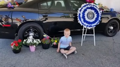Dakota, 5, spends time at the memorial created for his father, slain Terre Haute, IN, officer Rob Pitts.