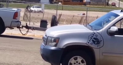 Two Casper, WY, officers take cover behind their vehicle Sunday during a gunfight that left an officer critically wounded. The suspect was killed.