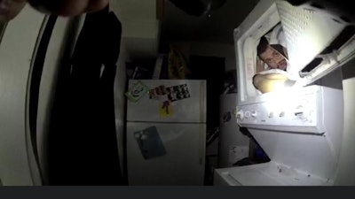 Screen grab of body camera footage of a search for a man that ended when he was discovered in a household dryer. Image courtesy of Spokane (WA) PD / Facebook.