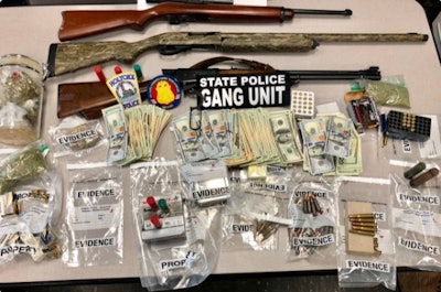 Police in Holyoke (MA) reportedly seized three long guns, ammunition, heroin, cocaine and several thousand dollars in cash in four simultaneous raids conducted on Tuesday. Image courtesy of Massachusetts State Police / Twitter.
