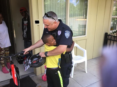 Officer Clift of the Kent (WA) Police Department gets a hug from a boy after gifting the child a bicycle. (Photo: Kent PD/Facebook)