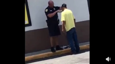 Screen grab of a video showing Officer Tony Carlson of the Tallahassee Police Department helping a homeless man apply for a job by giving him a fresh shave. Image courtesy of Tallahassee PD / Facebook.