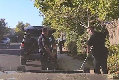 Two officers with the Elk Grove (CA) Police Department were 'caught in the act' of helping an 82-year-old man clear some overgrown shrubs and tree limbs from his property. Image courtesy of Elk Grove PD / Facebook.