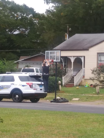 A Birmingham officer affixing brand new basketball netting for a hoop in front of a home. Photo: Rhaquel Ryans / Facebook