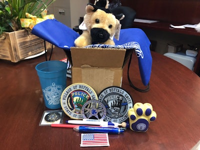 The Buffalo Grove (IL) Police Department posted an image on Facebook of the 'care package' they assembled, containing three versions of the agency's patch, a plush K-9, an American flag patch, a challenge coin and numerous other items. Image courtesy of Buffalo Grove PD / Facebook.