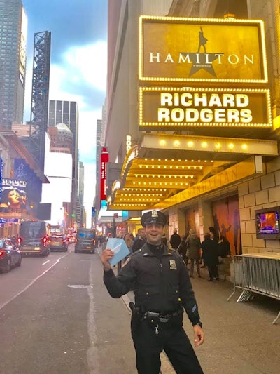 The department said in a Facebook post, 'When a first time visitor to NYC found out she was $20 short for tickets after standing in line for 4 days, she ran for help— and luckily met Officer Dicandia. He understood the magnitude of the emergency and pulled a 20 out of his pocket so she didn’t have to throw away her shot.' Image courtesy of NYPD / Facebook.