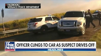 A Welasco, TX, police officer clings to a pickup truck as a motorist flees a traffic stop Sunday. (Photo: Fox News Screen Shot)