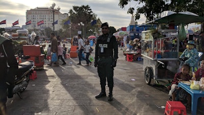 An officer in Phnom Penh, Cambodia standing in an open public market.