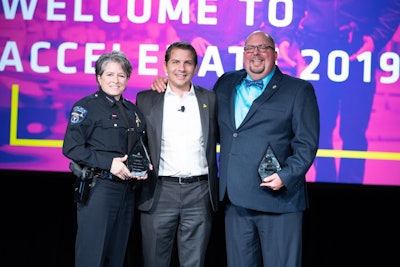 The recipients of this year's Rise Awards were Sylvia Moir, chief of police in Tempe, (AZ) and Chris Cognac, a recently retired officer who is the co-creator of the 'Coffee With a Cop' community policing program, flanking Axon President Luke Larson.