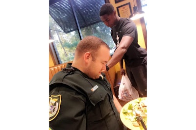 Juan O'Neal approached Officer Cameron Tucker and his wife Justine as they ate a meal at a local restaurant and asked permission to pray for the law enforcement officer.