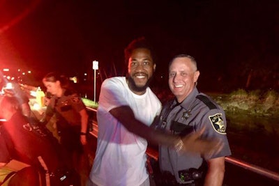 Deputy Robert Pounds the Collier County Sheriff's Office stands beside a happy new dad after helping deliver a baby at roadside.