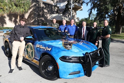 Curtis Moore (left)—a student at Palatka High School—was the artist with the winning design for a uniquely painted patrol vehicle for the school's resource officer, Deputy Doug Kennedy.