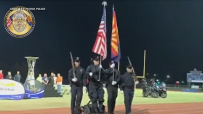 Paralyzed Peoria (AZ) Police Officer William Weigt (holding U.S. flag) stands for the first time in 14 years while serving on the honor guard for the Arizona Special Olympics. (Photo: Peoria PD)