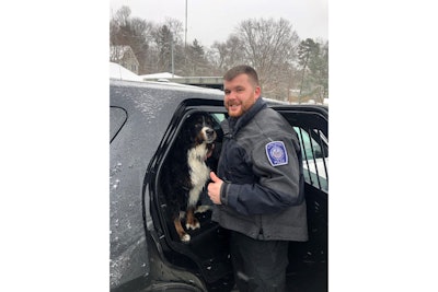 Officer Brian Casey with the wet—but happy—Tuukka in the back of his patrol vehicle following the dog's rescue from icy waters.