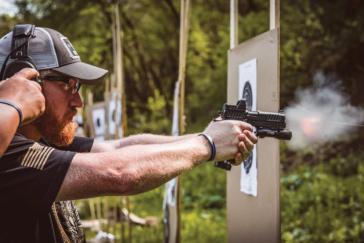 Police trainer Jim Dexter of the Lisle (IL) Police Department demonstrates the proper technique for shooting a pistol outfitted with red dot optics.