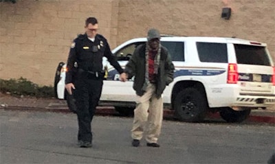 Phoenix Officer Joseph Mayfield assists an elderly man outside of a local shopping mall. A citizen snapped the photo and shared it on social media. (Photo: Phoenix PD/Twitter)