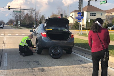 An officer with the Buffalo Grove (IL) Police Department was recently seen in an image posted to social media helping a stranded motorist change the tire on her vehicle.