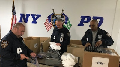 NYPD officer open a shipment of coronavirus face shields from Ford. (Photo: Ford)