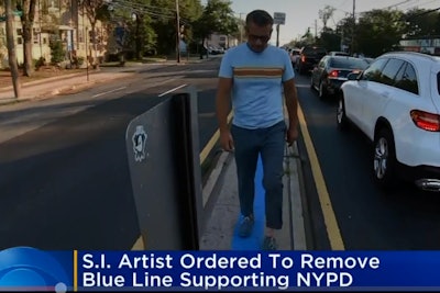An artist and activist who is a supporter of law enforcement officers recently painted a blue line in front of a police precinct house on Staten Island in New York. Now he's been told by city attorneys representing the Department of transportation that he must remove the paint and restore the pavement to its original condition.
