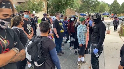 Protesters march outside the home of a Colorado Springs officer who was cleared in a fatal shooting that happened 12 months ago. (Photo: Screen Shot from Gazette Video)