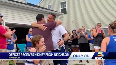 Green Township, OH, police officer Troy Biggs (white shirt) hugs his neighbor after finding out the man would be his kidney donor. (Photo: WLWT Screen Shot)