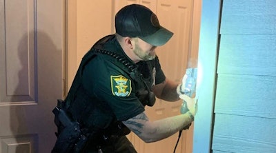 After clearing the residence, Deputy Lewis wanted to make sure the family felt safe for the rest of the night, so he grabbed some tools and bought some supplies to repair the damage to the doorway. (Photo: St. Johns County SO/Facebook)